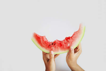 Hand with slice of watermelon on white backgroundの写真素材