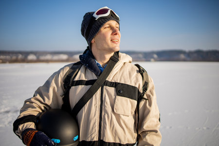 Man with a snowboard standing on a mountain on the background of the winter forest. Winter leisure activity. Healthy lifestyle. Extreme sports.の写真素材