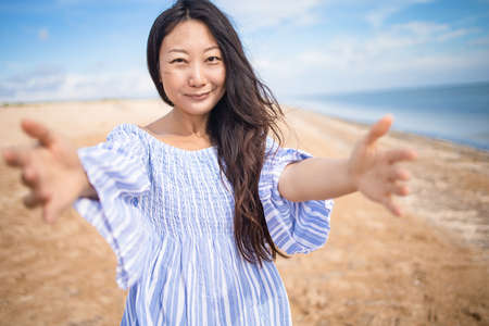 Portrait of happy asian pregnant woman smiling on the beachの写真素材