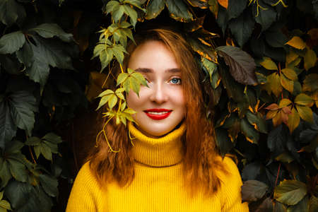 Beautiful girl walking outdoors in autumn park. Smiling Young woman enjoying autumn weather.
