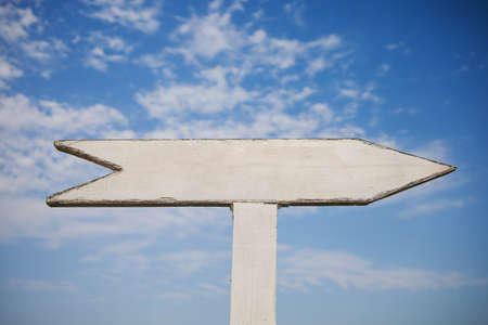 Empty wooden sign pointers with a space for text. On blue sky background.の写真素材
