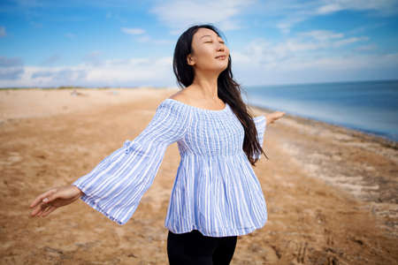 Portrait of happy asian pregnant woman smiling on the beachの写真素材