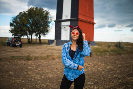 Asian woman sightseeing lighthouse seascape in europe travel outdoor recreation lifestyle concept. girl hair in the wind wearing a denim jacketの写真素材