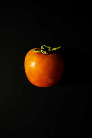 One fresh persimmon isolated on black background.の写真素材