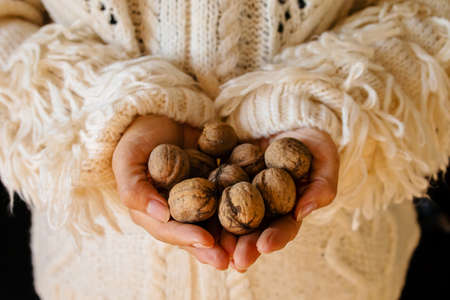Detail of woman's hands, holding a handful of organic walnuts. Selective focusの写真素材