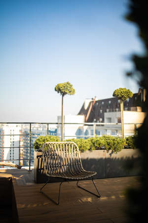 backyard with wicker chair for outdoor seating on the roof of the building. Beautiful house interior.の写真素材