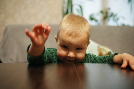 The funny child sits at an empty table.