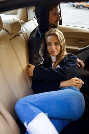 Young beautiful fashionable couple relaxing together while sitting inside a retro carの写真素材