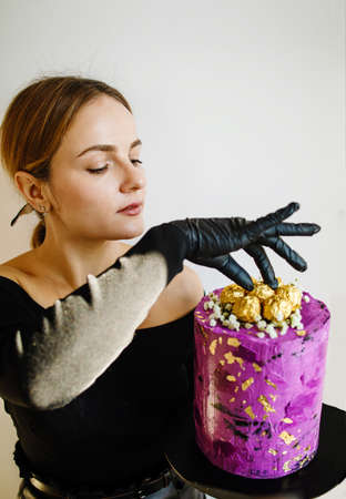 Housewife female chef cook confectioner or baker hold in hand cake in studio. Mock up copy space...