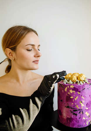Housewife female chef cook confectioner or baker hold in hand cake in studio. Mock up copy space...