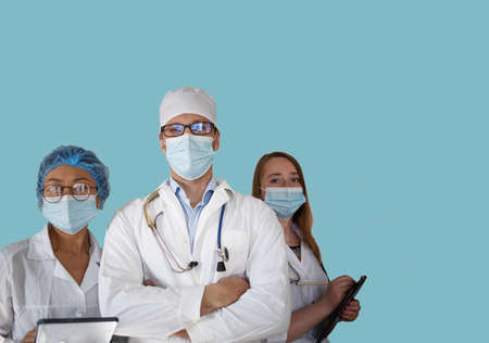 Successful team of doctors looking at camera and smiling while standing on blue background.の写真素材