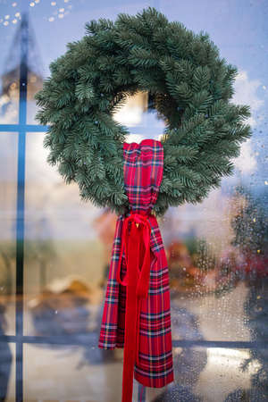 green christmas wreath with decorations red bow on window and door.の写真素材