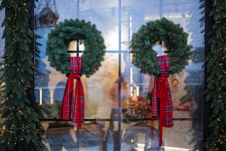 green christmas wreath with decorations red bow on window and door.の写真素材