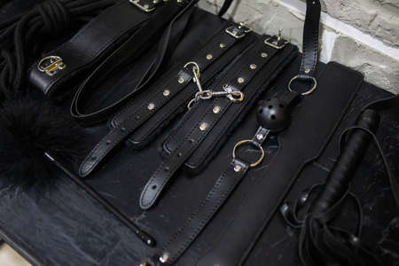 Set of toys for BDSM. The game of sexual slavery with a whip, gag and leather blindfold. Intimate sex gamesの写真素材