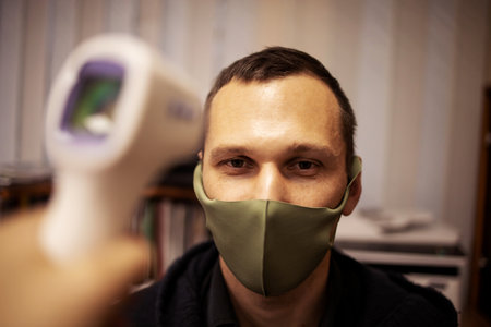 Disease control experts use an Infrared thermometer equipment to check the temperature on the...