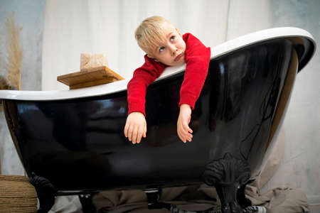 Sad Little boy sitting in bathtub and crying.の写真素材