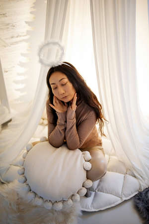 portrait of beautiful asian woman with white angel nimbus on headの写真素材