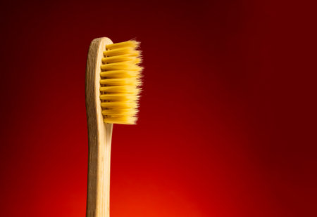 Wooden toothbrush isolated on a red backgroundの写真素材
