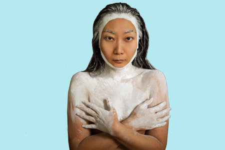 Portrait of a beautiful woman with creative makeup. Spa. Skin care and hair care. Hair mask of clay. Skin care concept.の写真素材