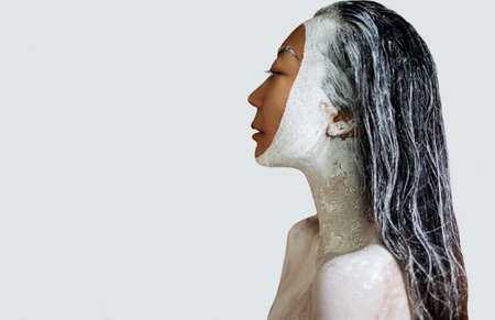 Portrait of a beautiful woman with creative makeup. Spa. Skin care and hair care. Hair mask of clay. Skin care concept.の写真素材