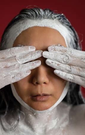 Portrait of a beautiful woman with creative makeup. Spa. Skin care and hair care. Hair mask of clay. Skin care concept.の写真素材