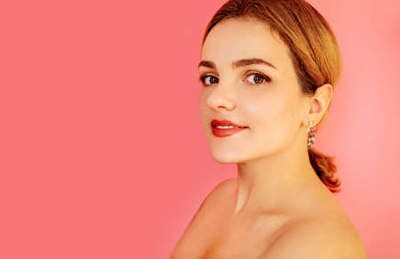 Beauty portrait of red head female face with natural skin on pink background.の写真素材