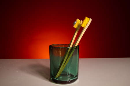 Holder with eco bamboo toothbrush on red background. Space for text No plastic concept.の写真素材