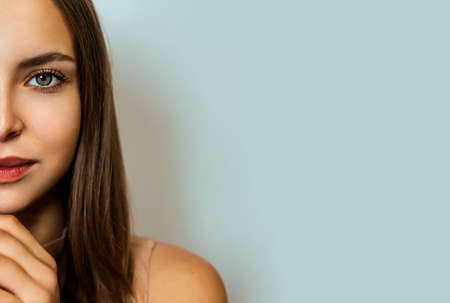 Beautiful blonde woman face close up studio on blue. Beauty Woman face Portrait. Beautiful Spa model Girl with Perfect Fresh Clean Skin. Youth and Skin Care Conceptの写真素材