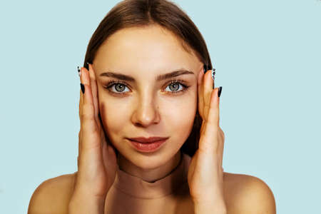 Beautiful blonde woman face close up studio on blue. Beauty Woman face Portrait. Beautiful Spa model Girl with Perfect Fresh Clean Skin. Youth and Skin Care Conceptの写真素材