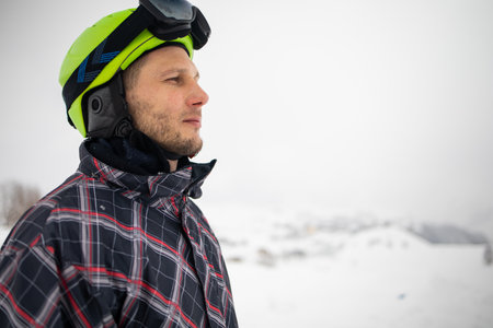 Portrait of man wearing a helmet and glasses on the background of snow winter and mounts.の写真素材