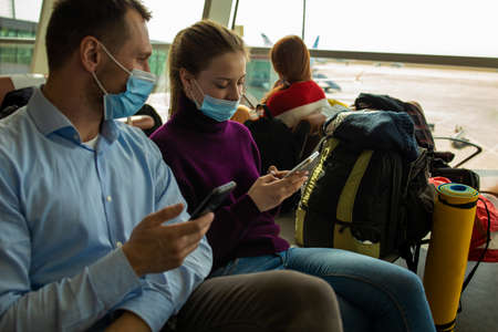 couple at airport using smartphone travel app.の写真素材