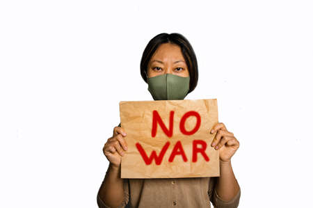 sheet of craft paper with white color inscription no war. Upset poor girl homeless protesting war conflict raises banner with inscription message text No War. Crisis, peace, stop aggression.の写真素材