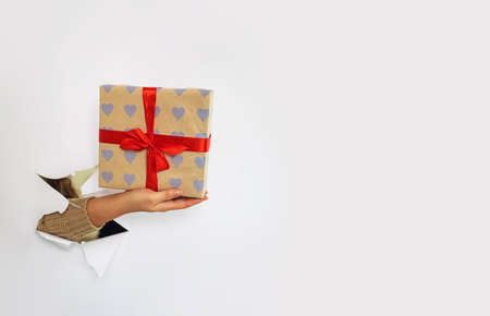 Hand hold vintage gift box with bow. gift box with a present for christmas, new year, valentine's day or anniversaryの写真素材