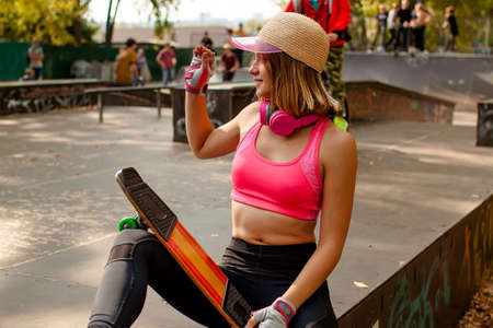 Smiling Teenager girl with skateboard portrait outdoors.