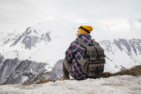 Active tourist with backpack enjoying the view on top of snowy mountain.の写真素材