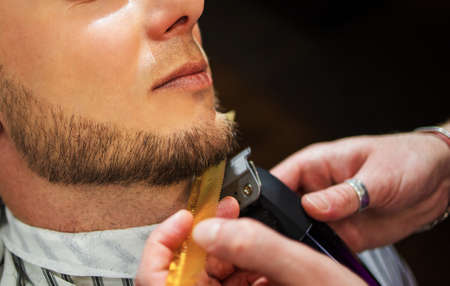 Close-up man hipster having barber shave barbershop hair machine.の写真素材