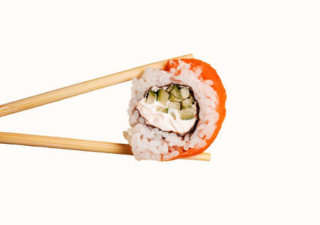 Female hands hold sushi rolls with chopsticks. white background. creative conceptの写真素材