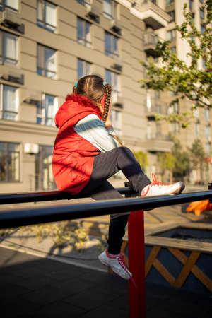 cute girl having fun at the playground. A child girl plays alone.