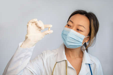 Asian female in a medical mask holding pillの写真素材