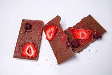 Handmade chocolate with fresh and dried berries, raspberries, strawberries on white background in rustic style, empty space for your text.の写真素材