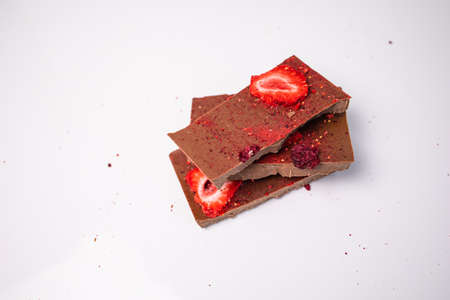 Handmade chocolate with fresh and dried berries, raspberries, strawberries on white background in rustic style, empty space for your text.の写真素材