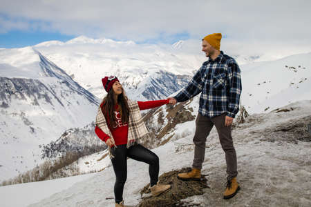 Image of happy couple hugging outdoors, young loving family having fun in snowy mountains, handsome...
