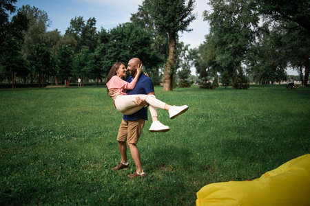 full length portrait of happy couple embracing in the garden. Loving couple hugging outdoors.の写真素材