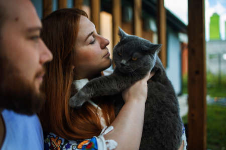 happy young caucasian couple at home with their catの写真素材