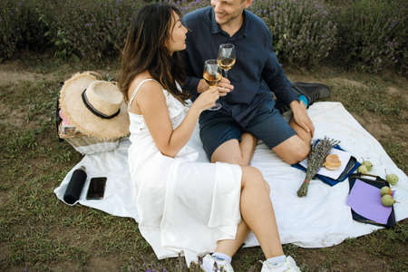 Couple on romantic picnic with french baguette in lavender field. vacation and travel concept.の写真素材