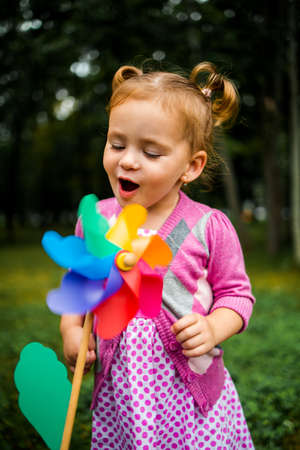 Cute little girl on the meadow in summer day