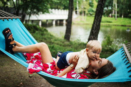 Young mother and little son in the park in the spring at sunset. happy family. weekend playtime conceptの写真素材