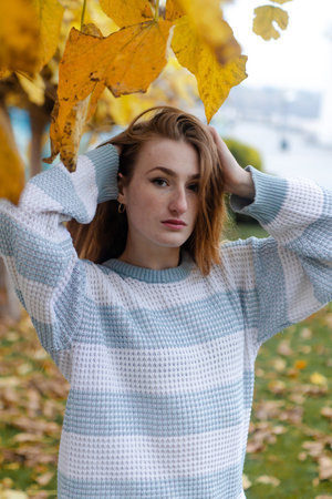 Beautiful woman in a sweater in the fall. Autumn beauty portrait of a fashionable Red-haired woman...
