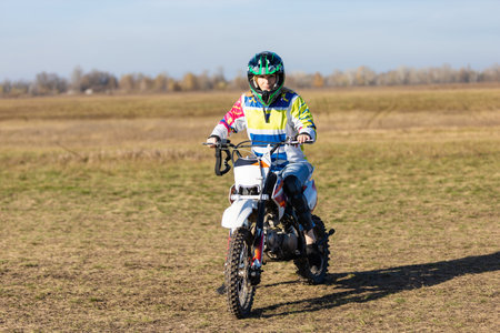 Beautiful woman in motorcycle outfit. Female motocross racer next to her motorcycle. female...