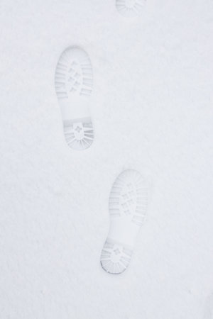 Top view of footprints in fresh snow. Imprint of shoes in the snow.